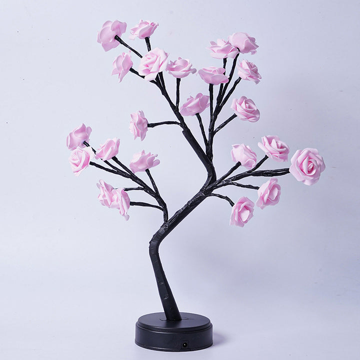 Rosenträdslampa med rosa rosor som lyser